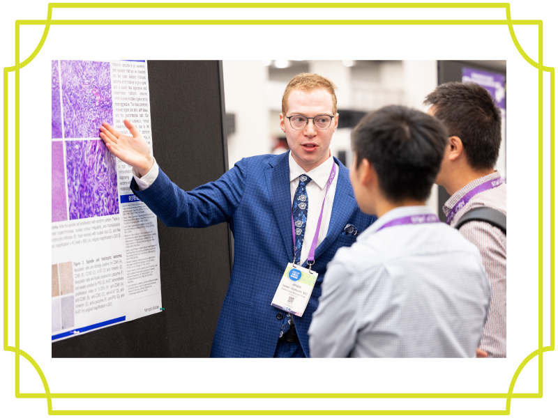 2025 annual meeting attendees talking and pointing at poster
